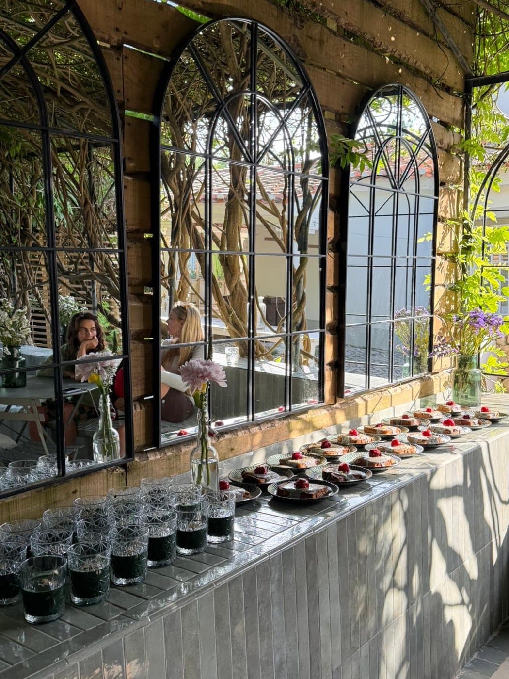 Women talking, reflected in the garden mirrors